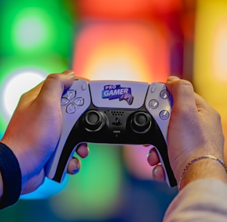 Two hands are holding a gaming controller labeled 'Pro Gamer'. The background is blurred with colorful lights creating a vibrant atmosphere.